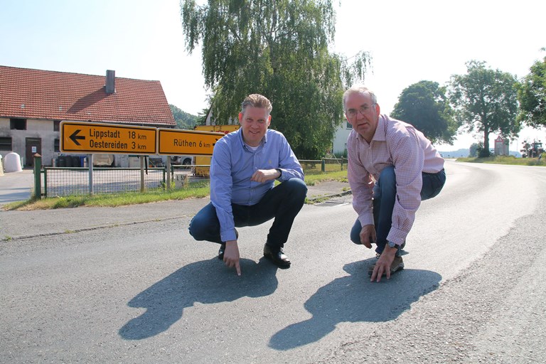 Jörg Blöming (l.) und Kellinghausens Ortsvorsteher Antonius Bertels verweisen auf die dringend notwendige Renovierung der Ortdurchfahrt, die ab August vorgenommen wird. 